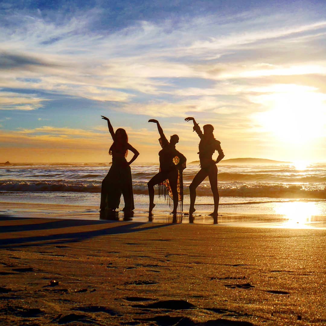 The resulting photograph: three figures dancing in silhouette against the Camps Bay sunset